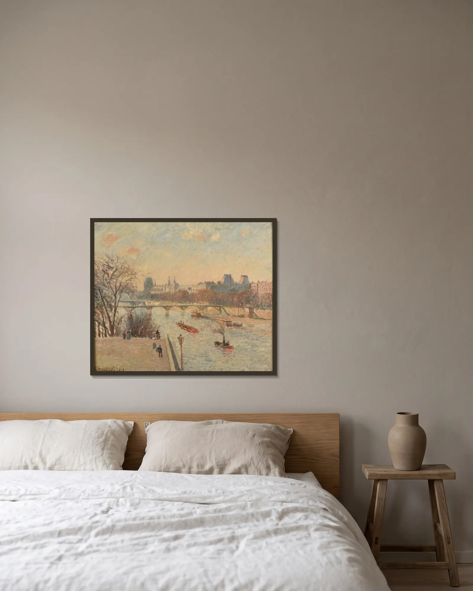 Le Louvre av Camille Pissarro inramad på en vägg