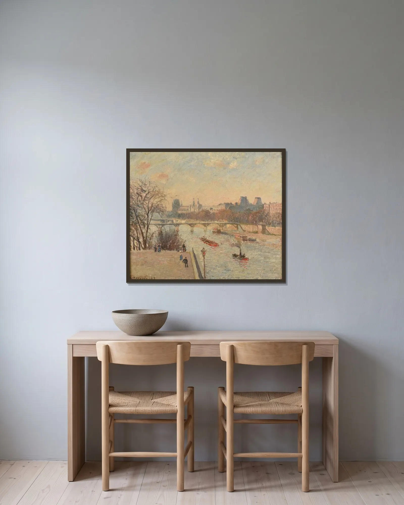 Le Louvre av Camille Pissarro inramad på en vägg