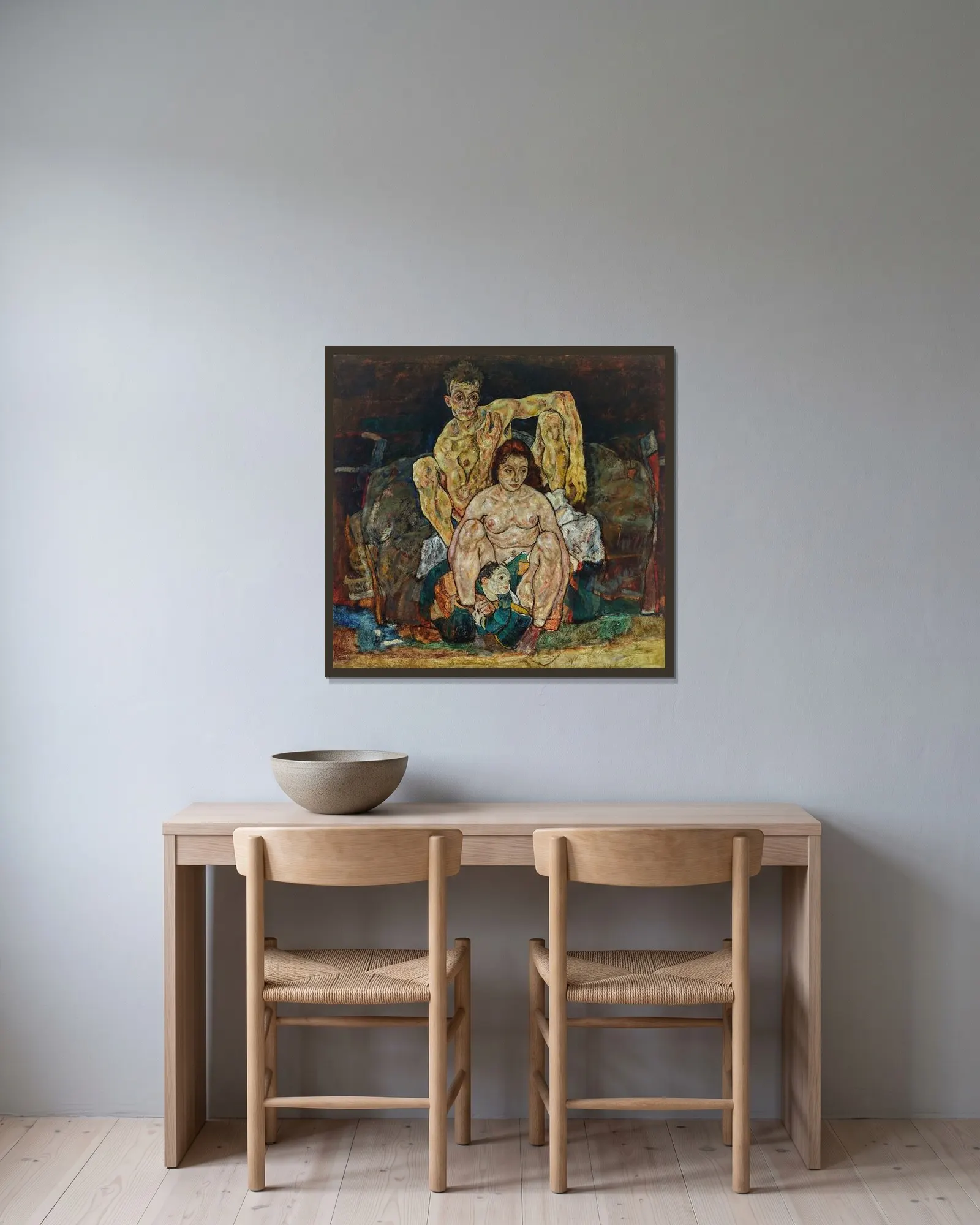 Kauerndes Menschenpaar (Die Familie) av Egon Schiele inramad på en vägg
