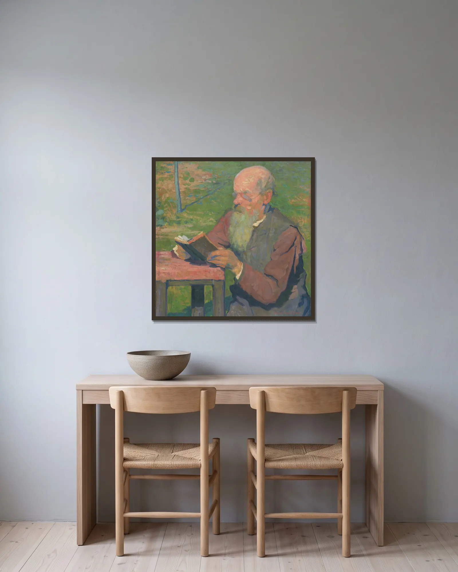 A reading old man av Elemír Halász-Hradil inramad på en vägg