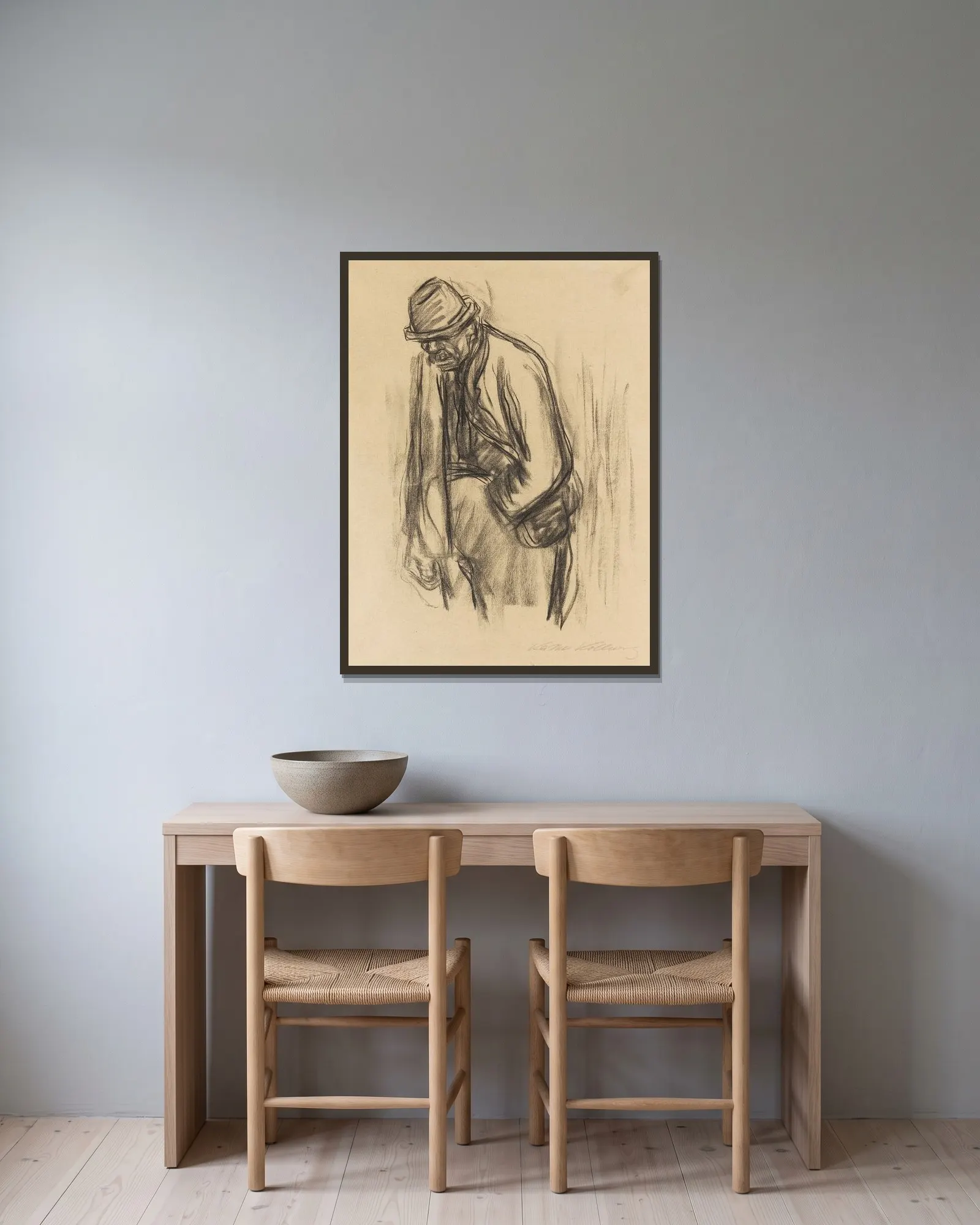 Mann mit Hut av Käthe Kollwitz inramad på en vägg