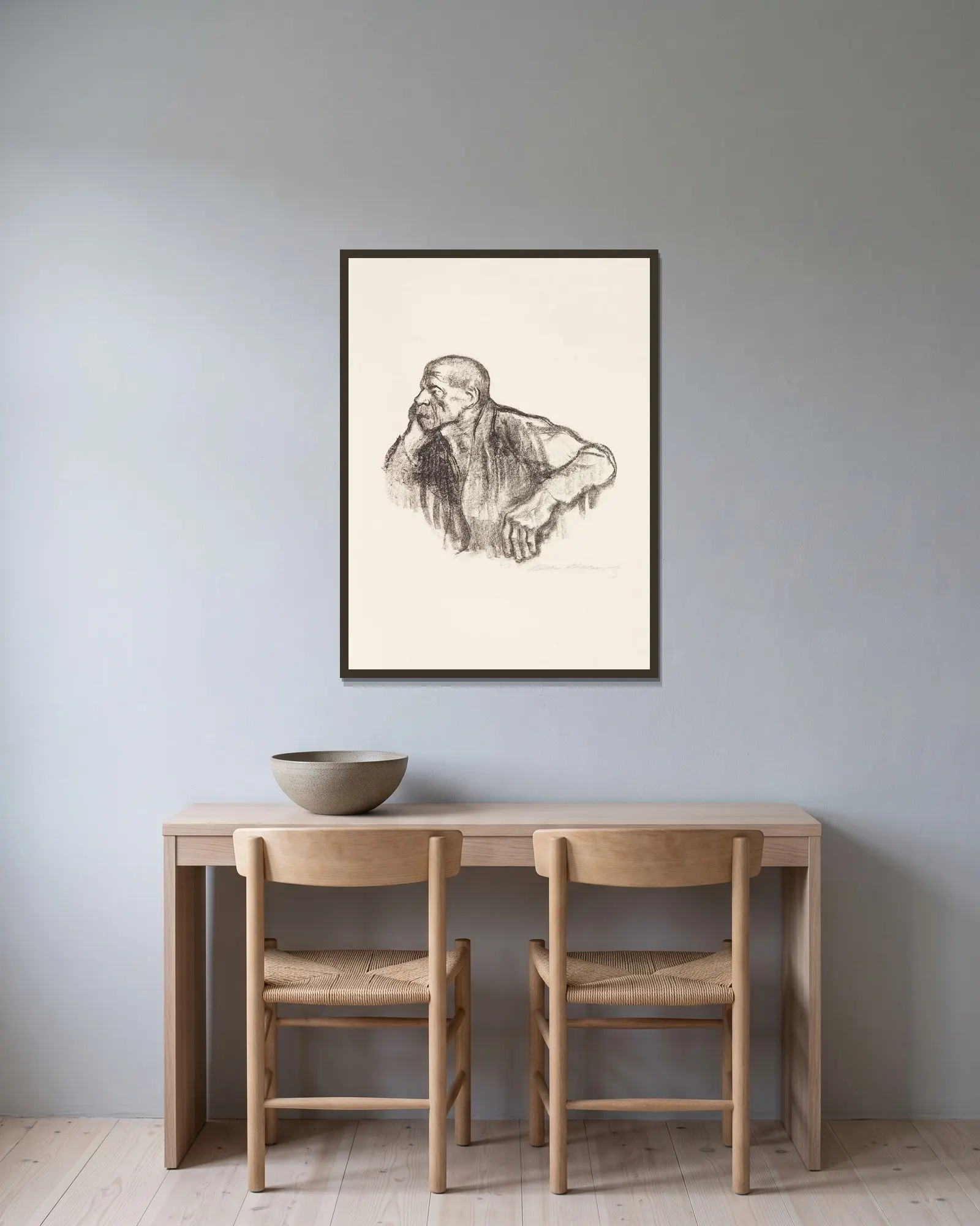 Sitzender Arbeiter av Käthe Kollwitz inramad på en vägg