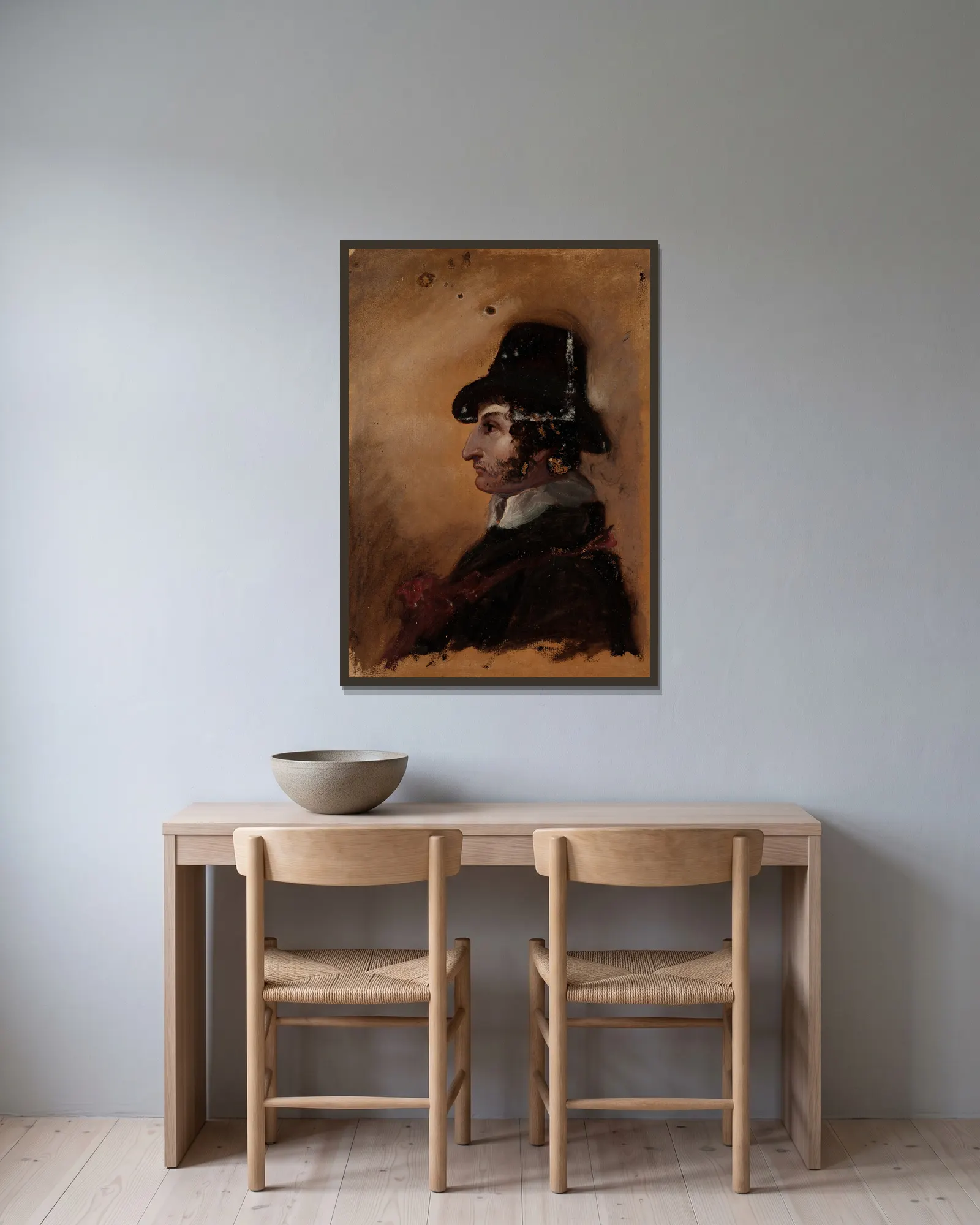 Man in a High Hat av Thomas Cole inramad på en vägg